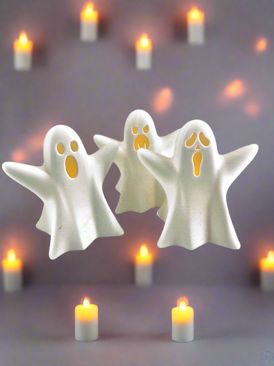 Three white ghost figurines with Tea lights
