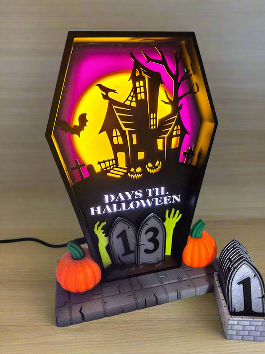 Halloween-themed decorative light with haunted house design and Tombstone countdown.